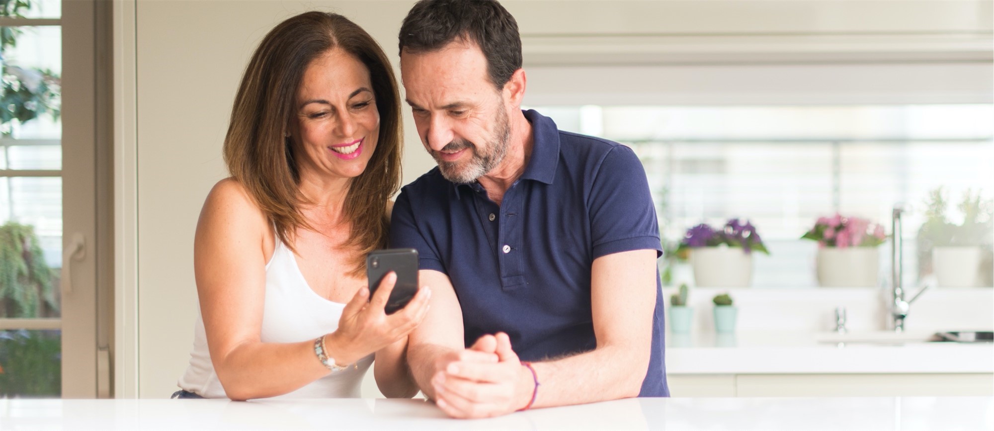Smiling couple looking at mobile phone